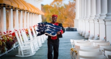 A bellman carrying American flags