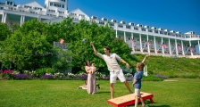 A family playing cornhole on the lawn