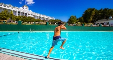 A young boy jumps into a pool