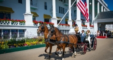 Bride and groom in horse drawn carriage in front of Grand Hotel
